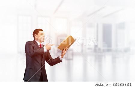 Senior businessman finger pointing into open book Senior businessman finger pointing into open book 83938331