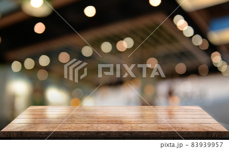 Empty wooden table top with lights bokeh on blur restaurant background. 83939957