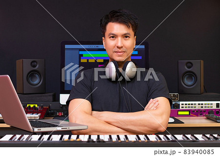 portrait of smiling asian professional music producer, composer, sound engineer, arranger in recording studio 83940085