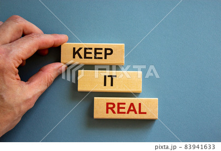 Male hand placing a block with word 'keep' on top of a blocks tower with words 'it real'. Beautiful blue background. Copy space. Business concept. Male hand placing a block with word 'keep' on top of a blocks tower with words 'it real'. Beautiful blue background. Copy space. Business concept. 83941633