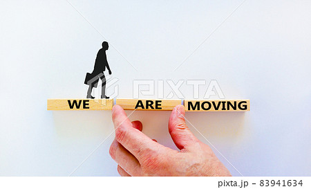 We are moving symbol. Wooden blocks with words 'We are moving'. Beautiful white background, businessman hand, businessman icon. Business, we are moving concept, copy space. 83941634