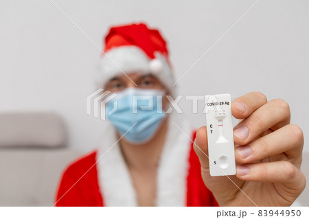 man dressed in Santa Claus hat showing test result man dressed in Santa Claus hat showing test result 83944950