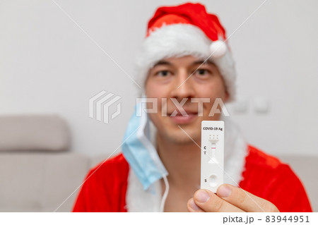 happy man dressed in Santa Claus hat showing negative test result 83944951