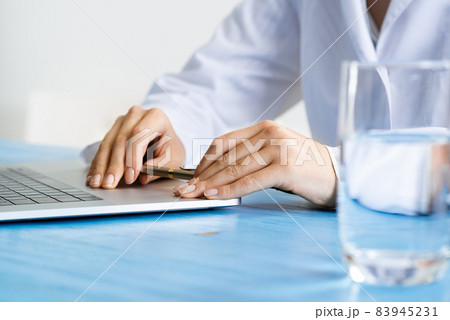 Close up of female doctor hands with laptop 83945231