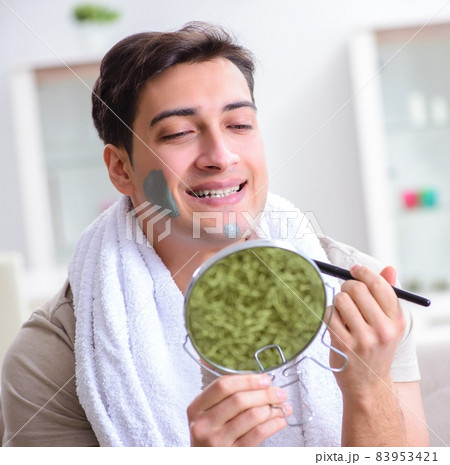Handsome applying clay mask on face 83953421