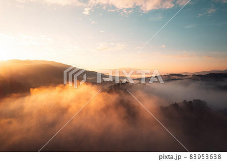 Flying above the clouds sunrise and fog Flying above the clouds sunrise and fog 83953638
