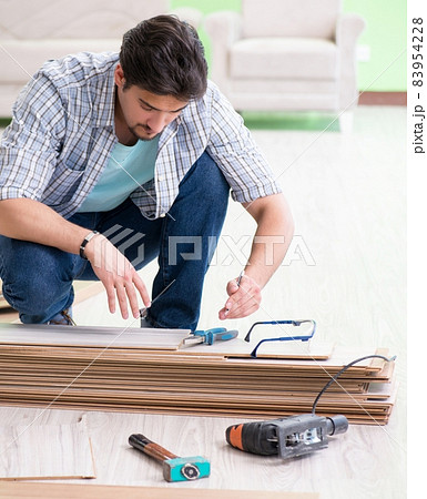 Man laying flooring at home 83954228
