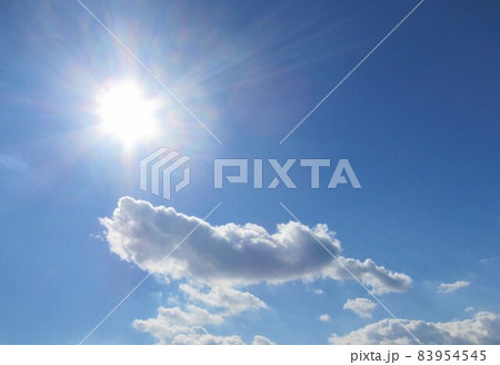太陽光のもと青空を泳いで行く灰色の綿雲① 83954545