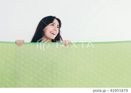 model with a banner in his hands on the background of pipes. Woman holding an invitation, business card, postcard. Brunette makes a presentation 83955879