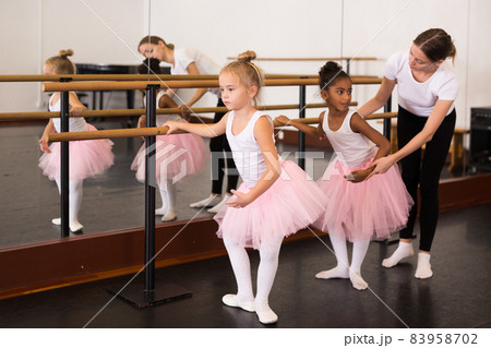 Ballet trainer teaching two little girls 83958702