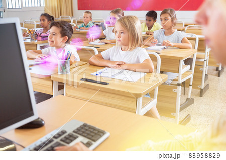 Preteen schoolchildren diligently working in class with teacher Preteen schoolchildren diligently working in class with teacher 83958829