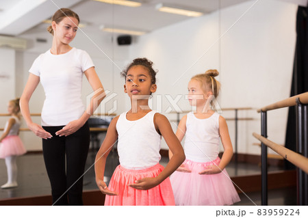 Dance teacher helping her little girls students 83959224