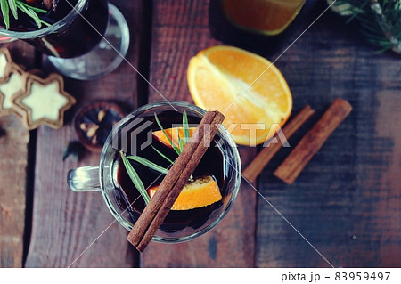 Cups with mulled wine, Christmas decorations, fir branches on a wooden background, the concept of home comfort, winter holidays celebration 83959497