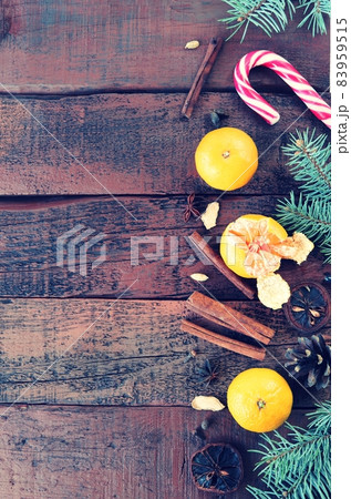 Christmas background, wood texture, decorated with spruce branches, spices, tangerines and candies, top view, copy space Christmas background, wood texture, decorated with spruce branches, spices, tangerines and candies, top view, copy space 83959515