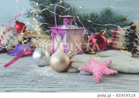 Christmas decorations, balls, spruce branches and a lantern with a burning candle, wooden on a background, the concept of New Year's greetings, postcard Christmas decorations, balls, spruce branches and a lantern with a burning candle, wooden on a background, the concept of New Year's greetings, postcard 83959518