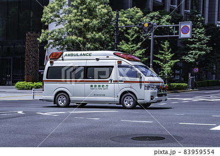 サイレンを鳴らし街中を走る緊急車両（救急車） 83959554