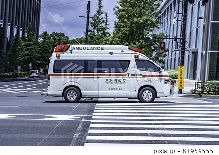 サイレンを鳴らし街中を走る緊急車両（救急車） 83959555