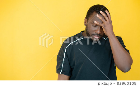 Facepalm gesture. Clueless man. Wtf reaction. Upset disappointed guy feeling epic fail covering face by hand isolated yellow copy space. 83960109