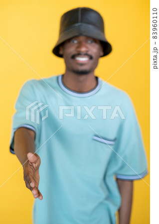 Nice meet you. Greeting hipster man. Friendly handshake. Happy guy in stylish leather hat proposing hand isolated yellow. 83960110