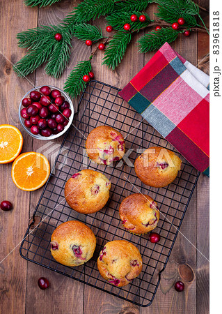 Cranberry orange muffins on cooling rack, vertical, top view, Christmas decoration on background Cranberry orange muffins on cooling rack, vertical, top view, Christmas decoration on background 83961818