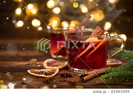 Christmas mulled red wine with spices and fruits on old wooden table. Christmas mulled red wine with spices and fruits on old wooden table. 83963000