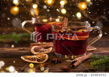 Christmas mulled red wine with spices and fruits on old wooden table. 83963032