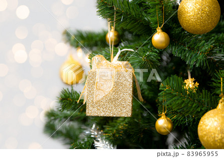 Christmas Tree with golden gift box and ornament on blurred light background, Holidays Concepts 83965955