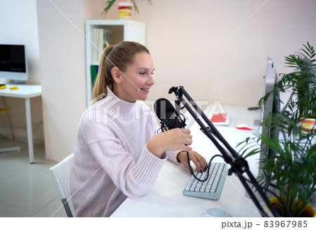 young woman is streaming while sitting in coworking at the computer young woman is streaming while sitting in coworking at the computer 83967985
