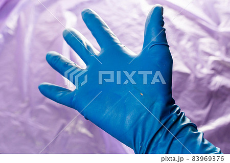 used blue protective glove with perforating hole on the inside of the palm used blue protective glove with perforating hole on the inside of the palm 83969376