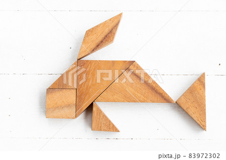 Wood tangram puzzle in fish or carp shape on white wood background 83972302