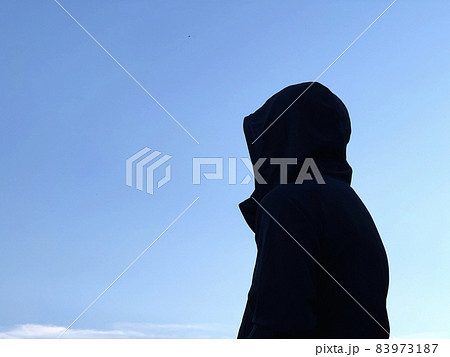 フードをかぶった怪しい男性_青空背景 フードをかぶった怪しい男性_青空背景 83973187