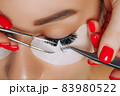 Eyelash Extension Procedure. Woman Eye with Long Eyelashes. Close up, selective focus. 83980522