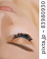 Eyelash Extension Procedure. Woman Eye with Long Eyelashes. Close up, selective focus. 83980930