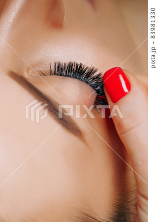 Eyelash Extension Procedure. Woman Eye with Long Eyelashes. Close up, selective focus. Eyelash Extension Procedure. Woman Eye with Long Eyelashes. Close up, selective focus. 83981330