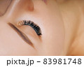Eyelash Extension Procedure. Woman Eye with Long Eyelashes. Close up, selective focus. 83981748