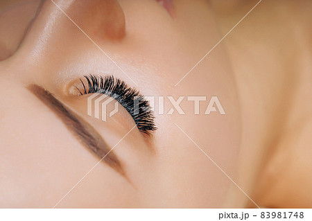 Eyelash Extension Procedure. Woman Eye with Long Eyelashes. Close up, selective focus. Eyelash Extension Procedure. Woman Eye with Long Eyelashes. Close up, selective focus. 83981748