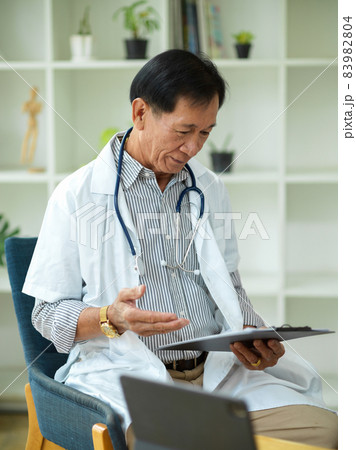 A middle-aged specialist male doctor checks and reads a treatment plan A middle-aged specialist male doctor checks and reads a treatment plan 83982804