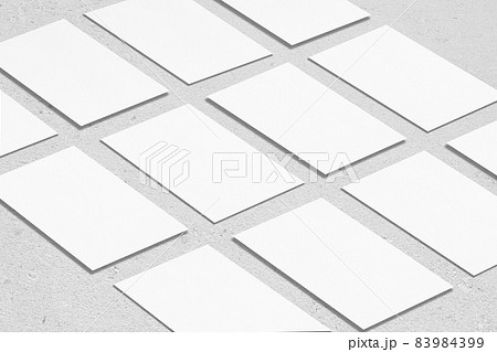 empty white rectangle business card mockups lying diagonally on neutral grey concrete background 83984399
