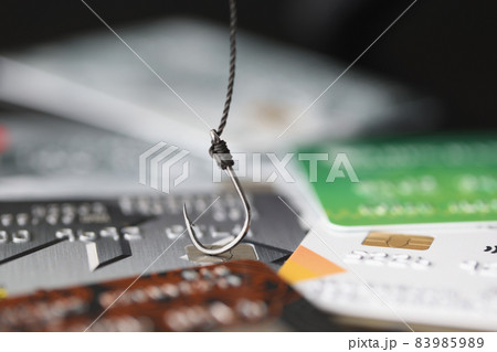 Fishing hook is hooked on plastic bank credit card closeup 83985989