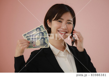千円札3枚を持ち通話する女性 千円札3枚を持ち通話する女性 83986381