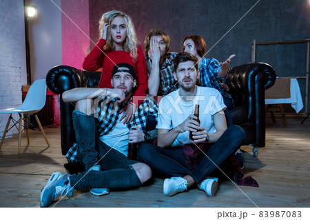 Group of friends watching TV match at home 83987083
