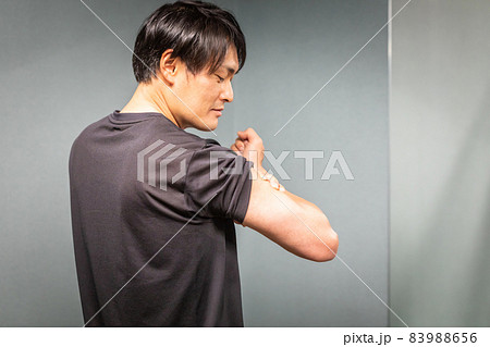 腕の筋肉を見る男性 83988656