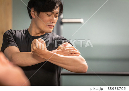 腕の筋肉を見る男性 83988706