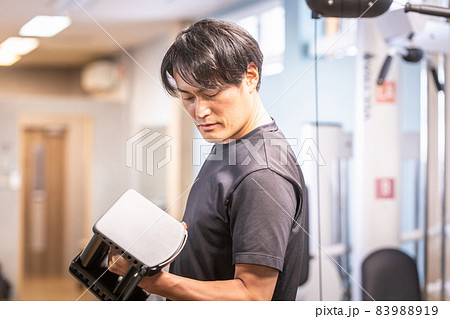 スポーツジムでブロックダンベルを使う男性 83988919