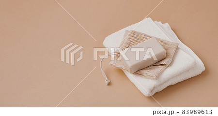 A bar of natural handmade soap lies on a soft white towel. Health beauty natural products concept. Organic natural cosmetics A bar of natural handmade soap lies on a soft white towel. Health beauty natural products concept. Organic natural cosmetics 83989613