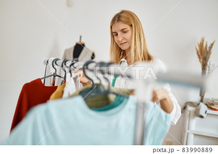 Seamstress choosing dress in atelier, dressmaker 83990889