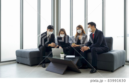 Group of business people in suit discuss about data on laptop computer. Everyone wears a mask. People corporate business team concept. 83991630