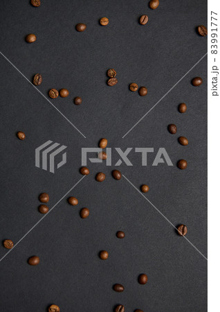 Flat lay composition of scattered fresh roasted coffee beans on a black background with copy space for advertisement Flat lay composition of scattered fresh roasted coffee beans on a black background with copy space for advertisement 83991777