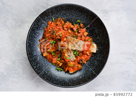 Top view of roasted zander served with steamed tomato, onion and olive sauce Top view of roasted zander served with steamed tomato, onion and olive sauce 83992772