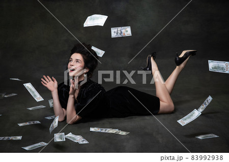 Creative portrait of young adorable woman in image of medieval royal person in black dress isolated on dark vintage background. 83992938
